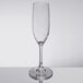 A clear Carlisle plastic champagne flute with a stem on a table.