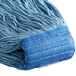 A close up of a blue Carlisle Flo-Pac wet mop head with a blue headband.