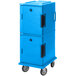 A light blue plastic Cambro food pan carrier with casters and black handles.