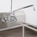 A stainless steel Equip by T&S add-on faucet over a sink in a kitchen.