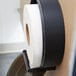 A Merfin Universal jumbo roll of toilet paper on a dispenser.