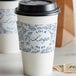 A white coffee cup sleeve with customizable embossed print.