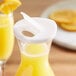 A white Choice hinged plastic carafe lid on a glass container of yellow liquid with a slice of orange on top.