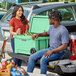 A man and woman standing in the back of a truck next to a CaterGator Seafoam outdoor cooler.