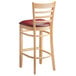 A Lancaster Table & Seating wood ladder back bar stool with a burgundy vinyl seat on white background.