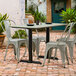 A Lancaster Table & Seating outdoor table and chairs on a brick patio.