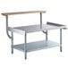 A Regency stainless steel equipment stand with a galvanized undershelf and wood cutting board on top.