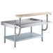 A Regency stainless steel equipment stand with a galvanized undershelf, plate shelf, and wooden cutting board.