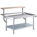 A Regency stainless steel equipment stand with a galvanized shelf and wooden cutting board.