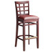 A Lancaster Table & Seating mahogany wood bar stool with a burgundy cushion.