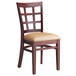 A Lancaster Table & Seating mahogany wood window back chair with light brown vinyl seat.