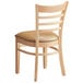 A Lancaster Table & Seating natural finish wood chair with a light brown vinyl seat and ladder back.