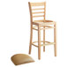 A Lancaster Table & Seating natural wood bar stool with light brown cushion seat detached.