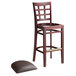 A Lancaster Table & Seating mahogany wood bar stool with a detached dark brown cushion seat.