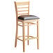 A Lancaster Table & Seating wooden ladder back bar stool with dark brown vinyl seat.