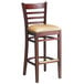 A Lancaster Table & Seating mahogany wood ladder back bar stool with a light brown vinyl seat.