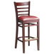 A Lancaster Table & Seating mahogany wood bar stool with burgundy vinyl seat.