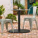 A Lancaster Table & Seating Excalibur outdoor table base on a brick patio.