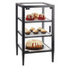 A black Cal-Mil bakery display case with shelves of pastries.