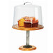 A Madera rustic pine footed pedestal cake stand with a cake and glass cover.