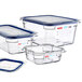 A group of three Araven clear plastic food pans with blue lids.