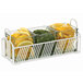 A white Cal-Mil condiment organizer with three glass jars filled with lemons and herbs.