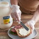 A person spreading Best Foods Real Mayonnaise on a sandwich.