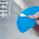A person using an Ateco blue and white pastry brush to sculpt blue dough.