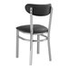 A Lancaster Table & Seating black vinyl chair with silver legs.