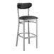 A black bar stool with a clear coat finish and black vinyl seat and back.