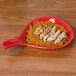 A CAC red spoon shaped bowl with rice and chicken on a plate.