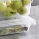A clear polycarbonate Vigor food storage box with green apples inside.