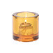 A Hollowick round amber glass tealight holder with a lit candle inside.