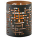A gold and black Hollowick candle holder with geometric designs holding a lit candle.