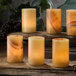 A group of Hollowick Onyx Cylinder Lamps with lit candles on a table.