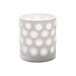 A white Hollowick porcelain votive holder with circles on it.