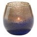A blue and gray bubble glass votive with a lit candle inside.
