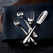 A Sola Cloud stainless steel dessert fork and knife on a blue cloth.