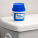 A white container with a blue label for Continental P222 Automatic Toilet Bowl Cleaner on top of a toilet tank.