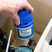 A hand holding a blue and white container of Continental P222 Automatic Toilet Bowl Cleaner.