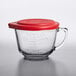 An Anchor Hocking clear glass measuring cup with a red lid.