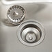 A close-up of an Advance Tabco stainless steel sink drain.