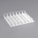 An Avantco white plastic tray with seven lanes and six compartments for 32 oz. bottles.
