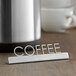 An American Metalcraft stainless steel table sign with "Coffee" on a table.