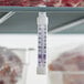 A Comark refrigerator/freezer thermometer hanging from a shelf.