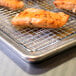 A piece of grilled salmon on a Footed Cooling Rack.