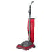 A Sanitaire TRADITION upright vacuum cleaner with a red bag and red handle.