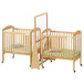 A Jonti-Craft wooden crib divider on wheels separating two cribs.