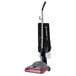 A Sanitaire upright vacuum cleaner with a red handle and black wheels.