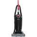 A black and red Sanitaire bagged upright vacuum cleaner.